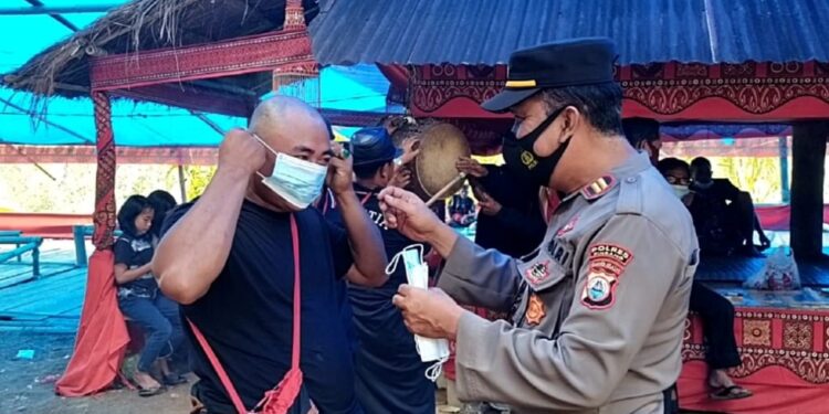 Hadiri Prosesi Pemakaman Adat Rambu Solo, Kapolsek Lembang Beri Imbauan dan Bagikan Masker